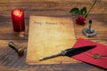 Classic Valentine`s Day cad with decorative quill and stand, red envelop with wax seal, red candle and rose, space for your text Royalty Free Stock Photo